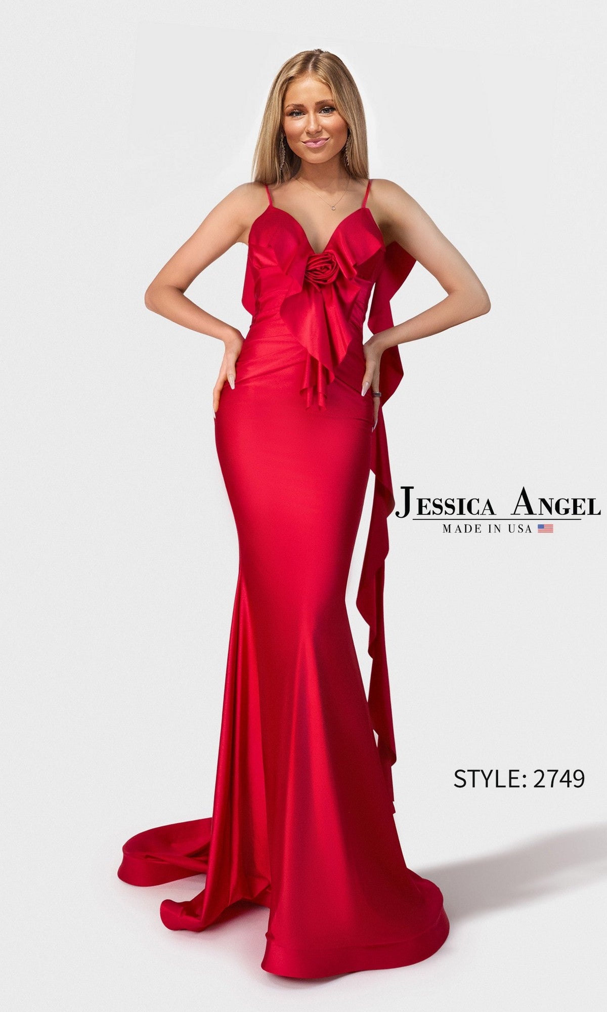 A woman wears the Jessica Angel 2749 long red prom dress, featuring a fitted, floor-length silhouette in stretch satin with a large bow and rose detail at the sleeveless bodice.
